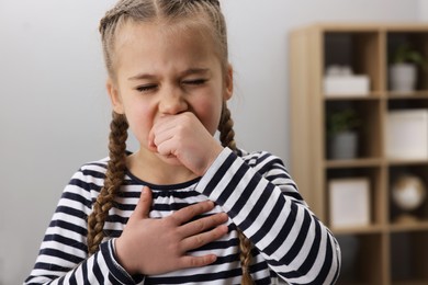 Photo of Sick girl coughing at home. Cold symptoms