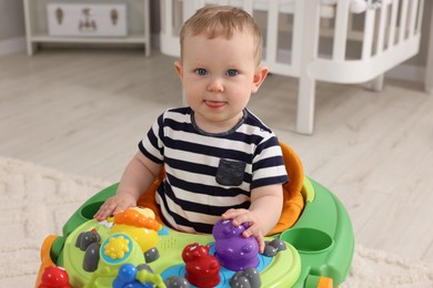 Photo of Portrait of cute baby with toy walker at home. Learning to walk