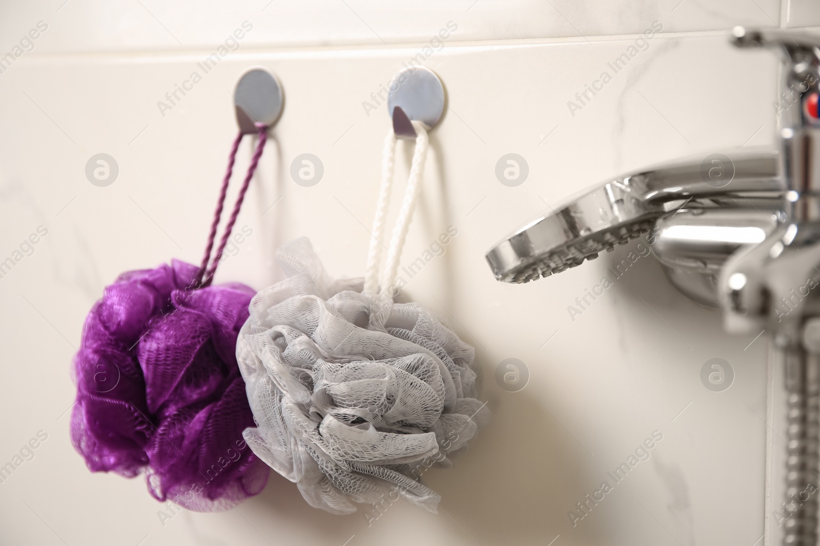 Photo of Shower puffs hanging near faucet in bathroom