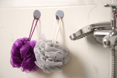 Shower puffs hanging near faucet in bathroom