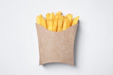 Paper cup with French fries on white table, top view