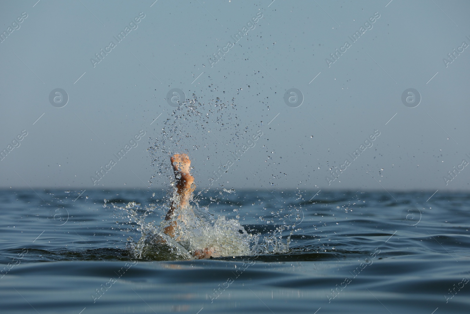 Photo of Drowning woman's leg sticking out of sea