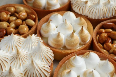 Photo of Many different tartlets on grey table, closeup. Delicious dessert
