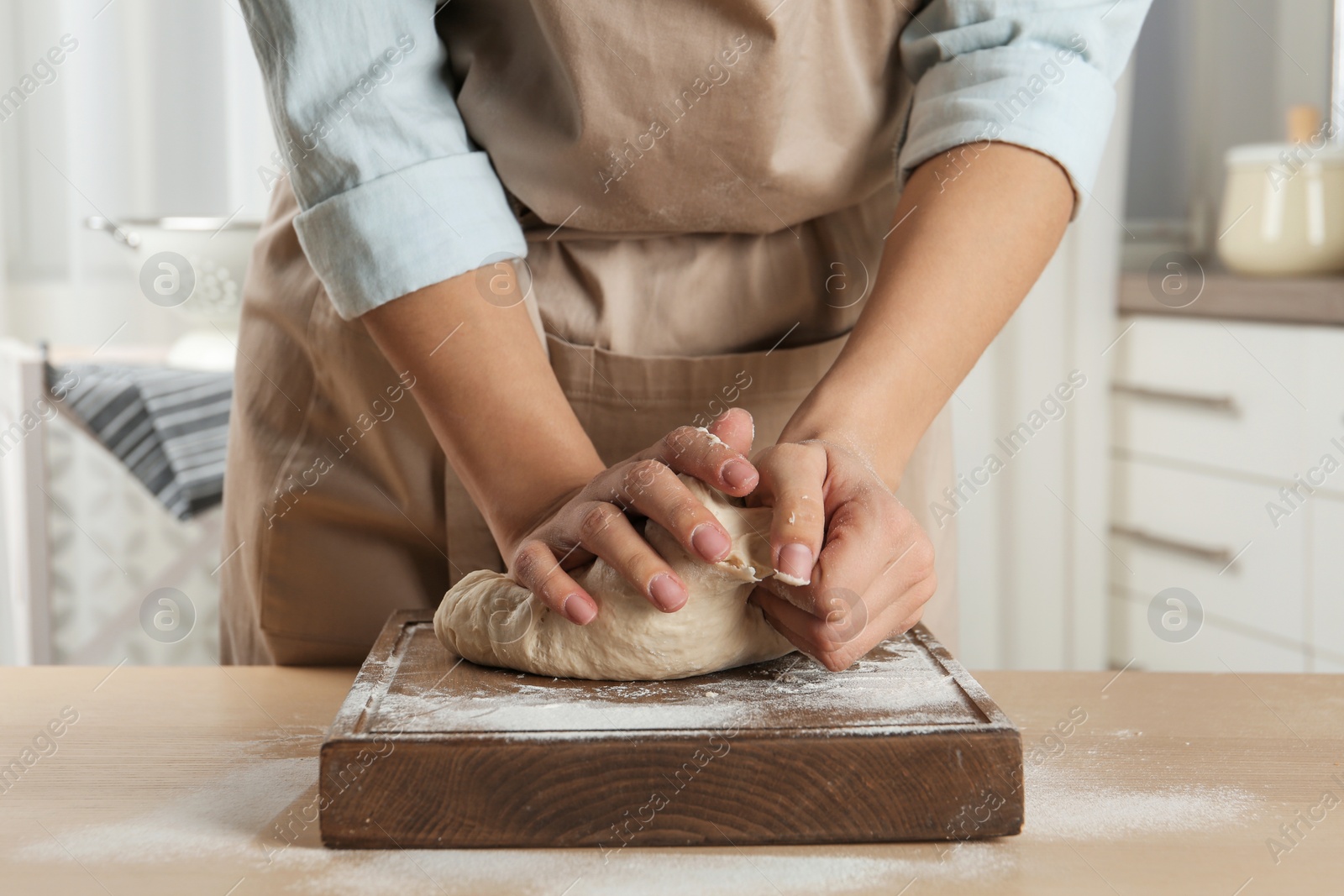 Photo of Female baker preparing bread dough at table, closeup