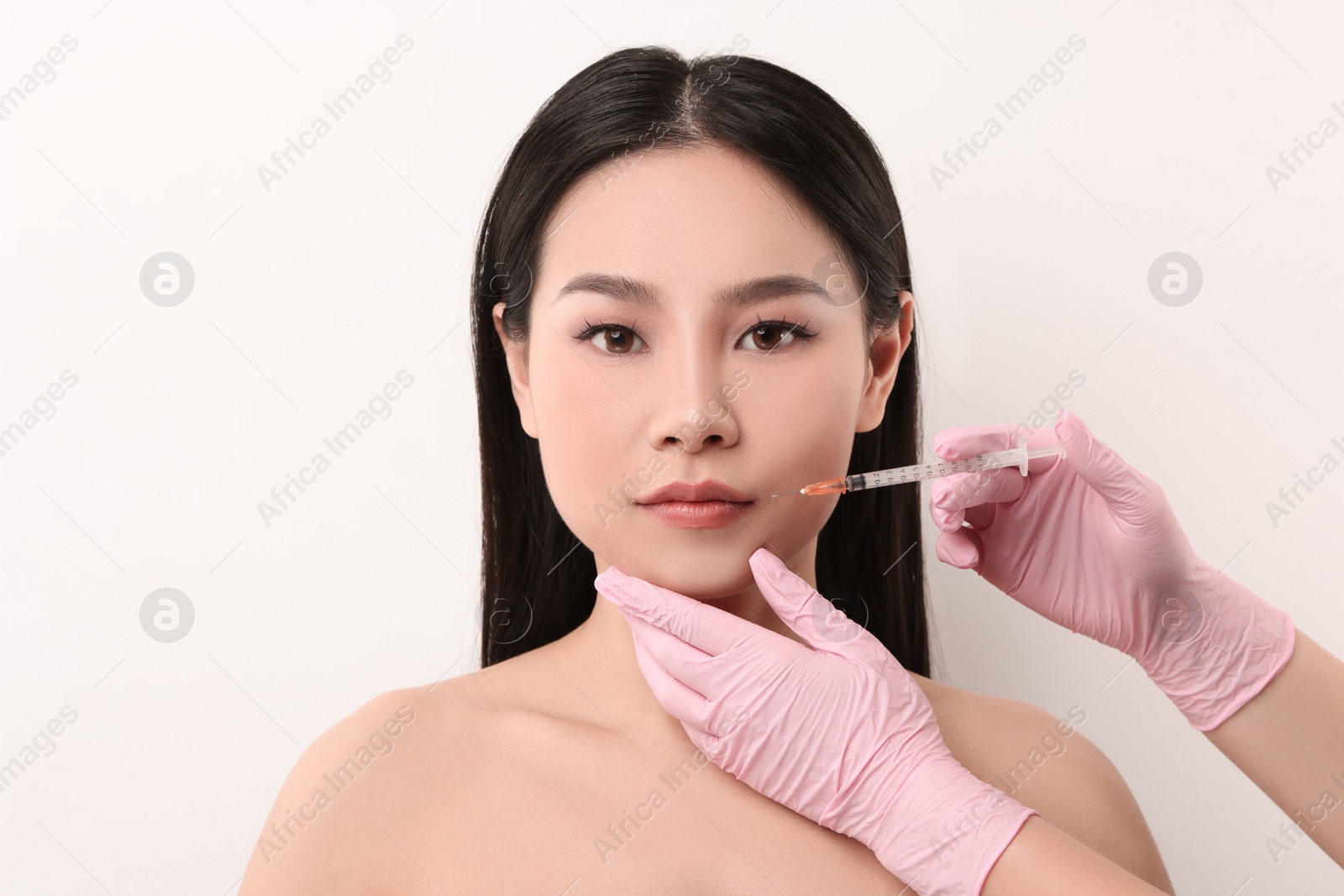 Photo of Woman getting lip injection on white background