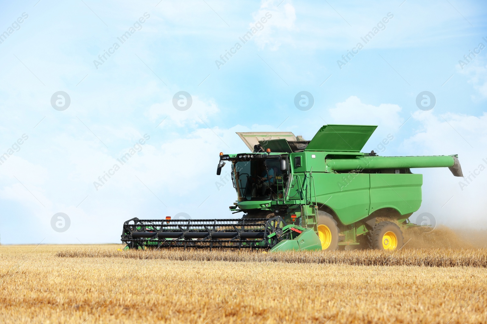 Photo of Modern combine harvester working in agricultural field