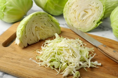 Photo of Chopped ripe cabbage on wooden board, closeup