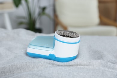 Modern fabric shaver on light grey cloth indoors, closeup