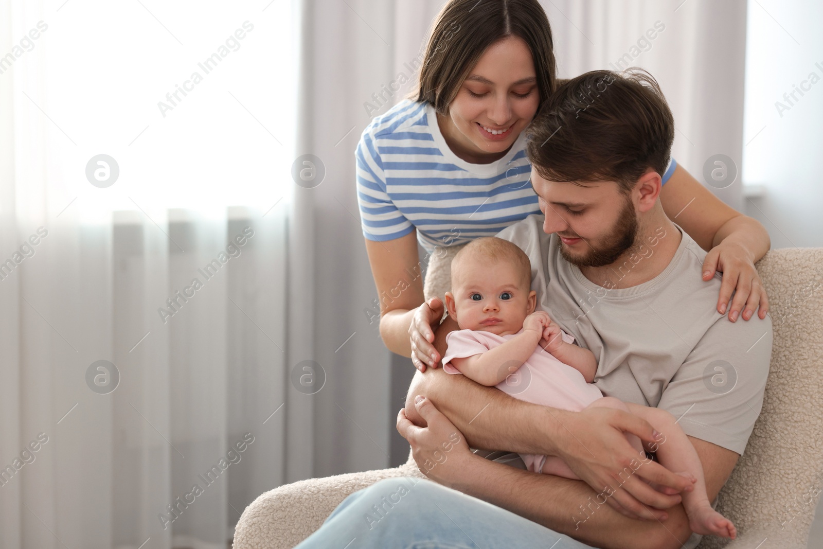 Photo of Happy family. Parents with their cute baby at home, space for text