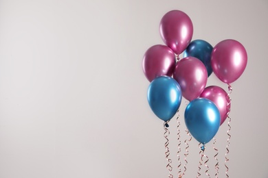Photo of Bright balloons on light background. Space for text