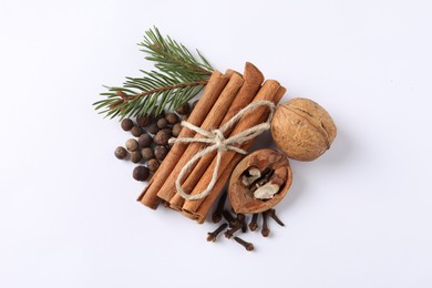 Photo of Different spices and fir branches on white table, flat lay