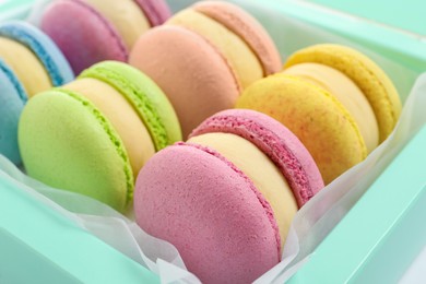 Photo of Many delicious colorful macarons in box, closeup