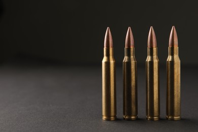 Photo of Bullets on black background, closeup. Space for text