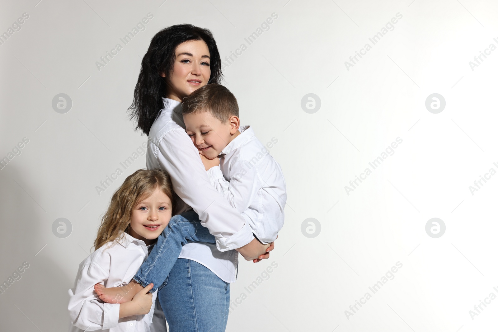 Photo of Little children with their mother on white background. Space for text