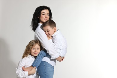 Photo of Little children with their mother on white background. Space for text