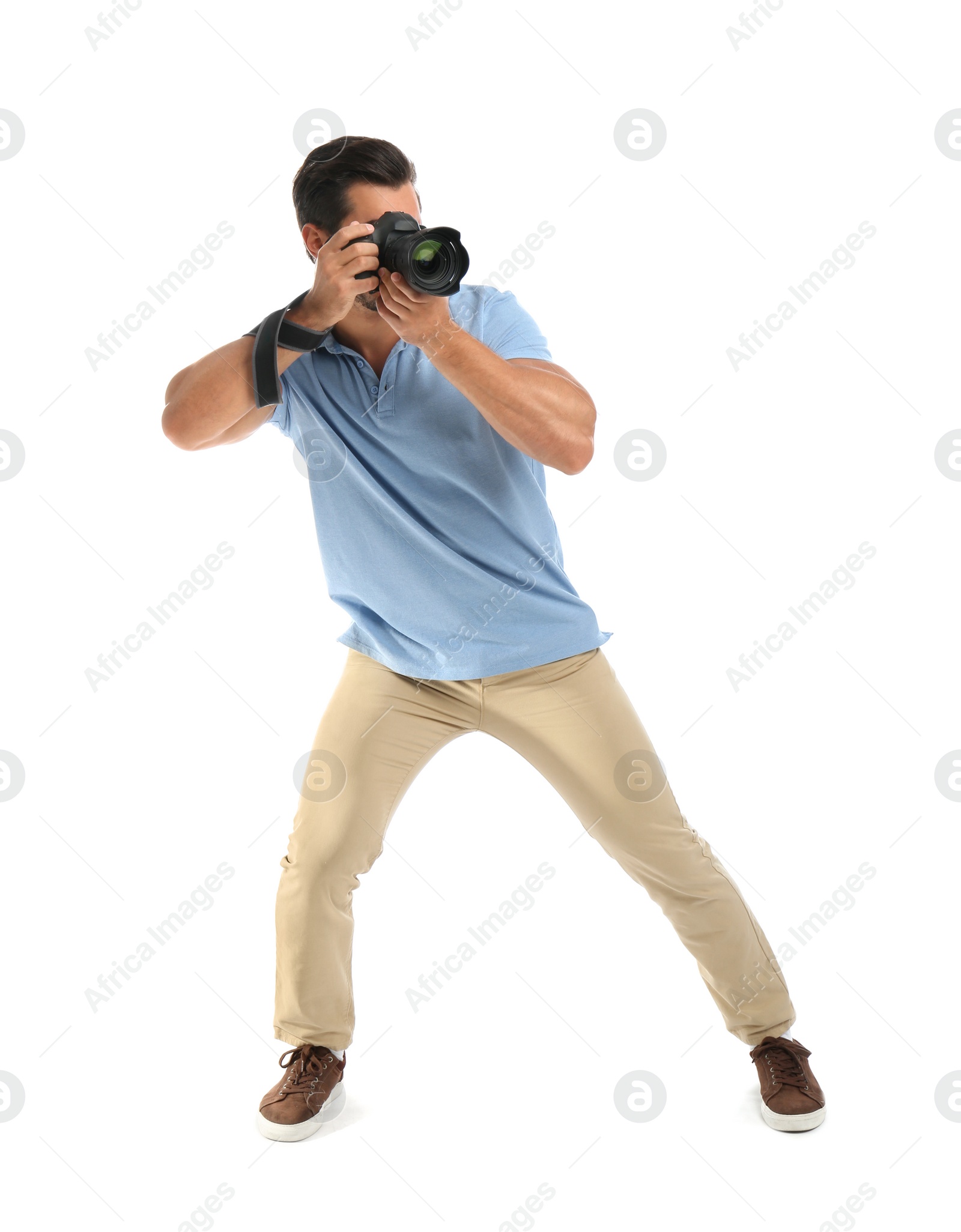 Photo of Young professional photographer taking picture on white background