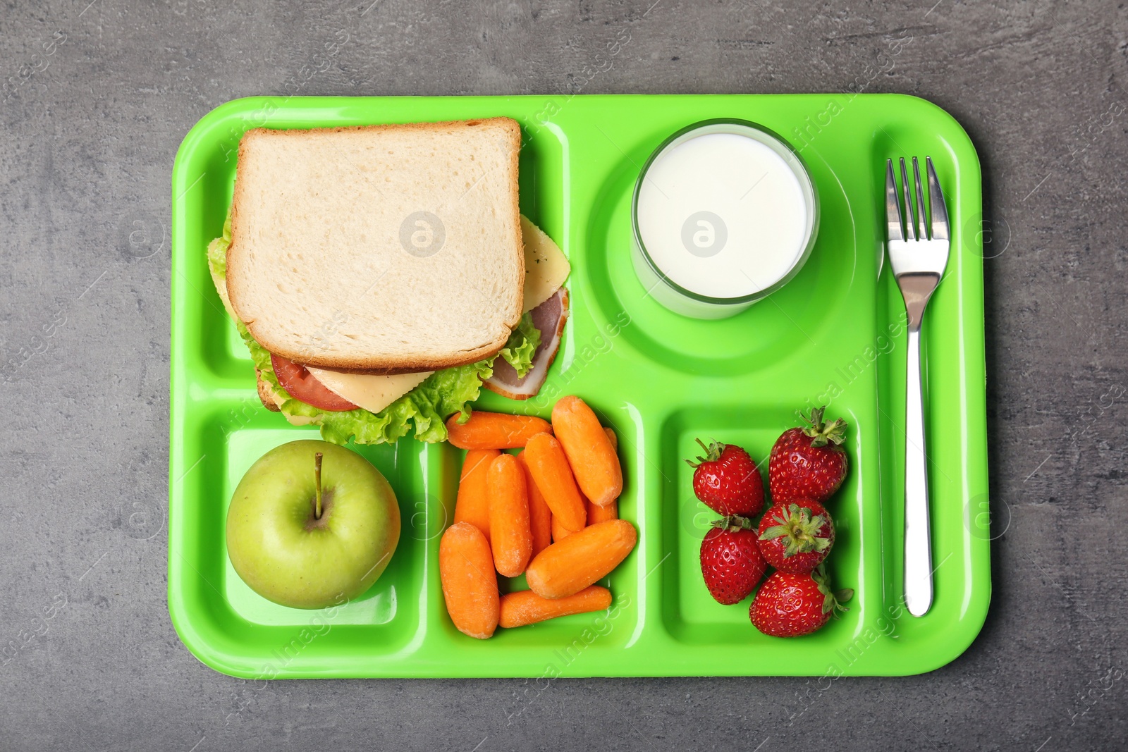 Photo of Serving tray with healthy food on gray background, top view. School lunch