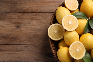 Many fresh ripe lemons on wooden table, top view. Space for text