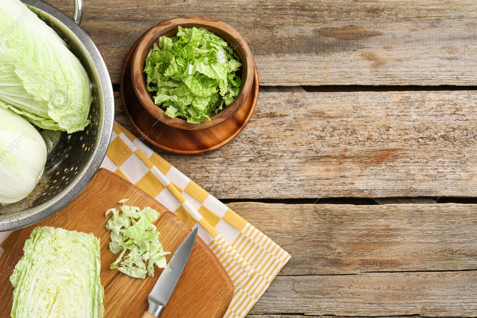 Photo of Fresh Chinese cabbages and knife on wooden table, top view. Space for text