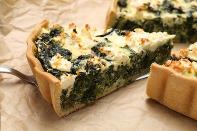 Photo of Delicious homemade spinach quiche on parchment paper, closeup