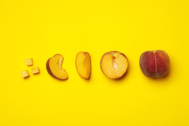 Flat lay composition with ripe peaches on yellow background, space for text