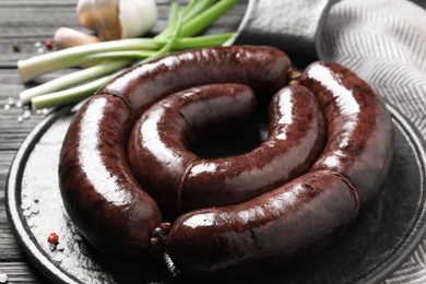 Tasty blood sausages served on black wooden table, closeup