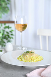 Photo of Delicious risotto with cheese on grey marble table indoors