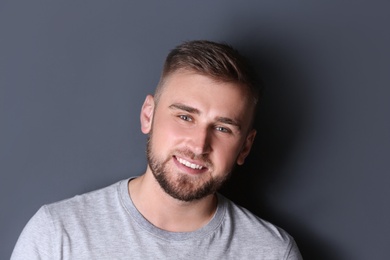 Portrait of handsome happy man on grey background