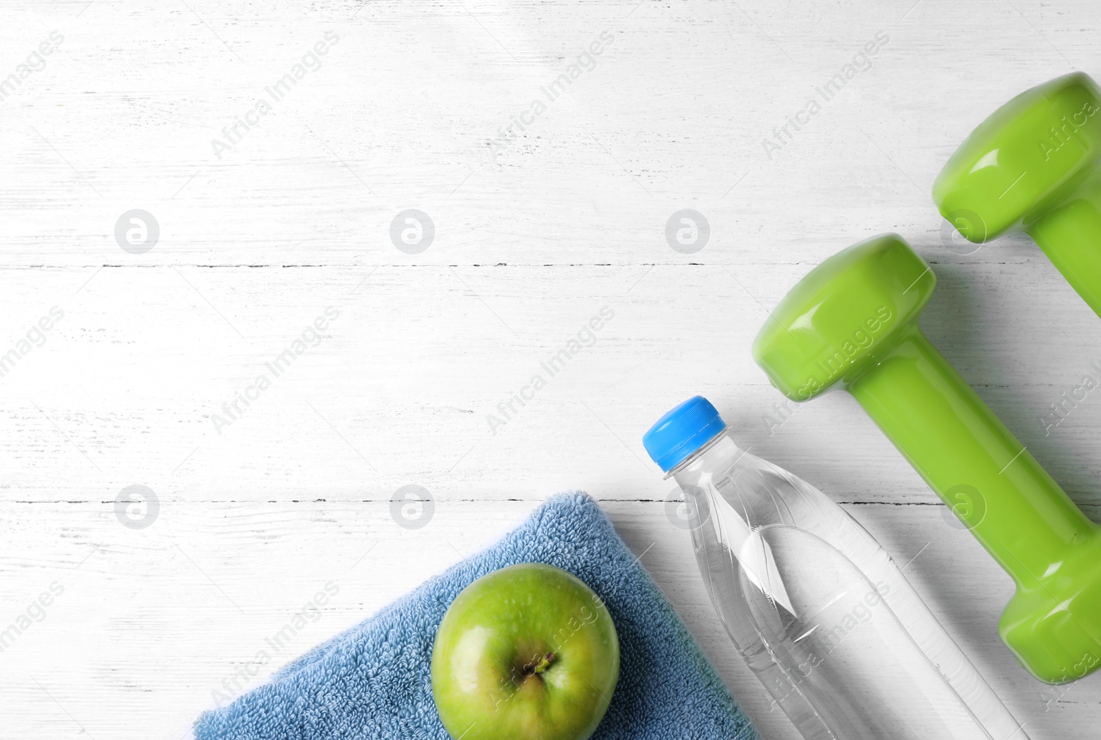 Photo of Flat lay composition with dumbbells and space for text on wooden background. Home fitness