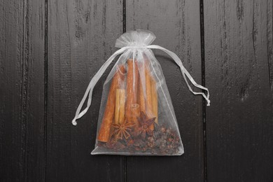 Scented sachet with cinnamon sticks and anise stars on wooden table, top view