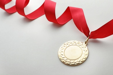 Photo of Gold medal on white background, space for text. Symbol of victory