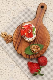 Photo of Delicious ricotta bruschetta with strawberry and walnut served on table, flat lay