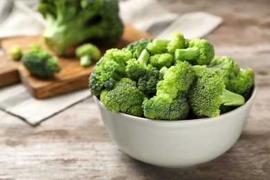 Bowl with fresh green broccoli on table