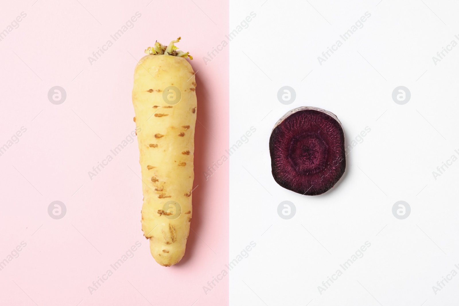 Photo of Raw white and purple carrots on color background, flat lay