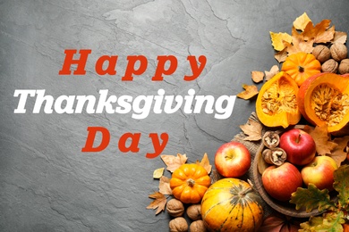 Image of Happy Thanksgiving Day card. Flat lay composition with vegetables, fruits and autumn leaves on black slate table