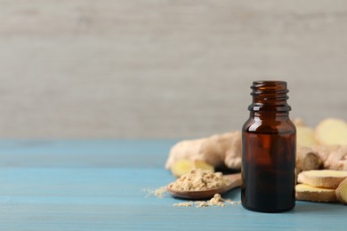 Glass bottle of essential oil and ginger root on light blue wooden table, space for text