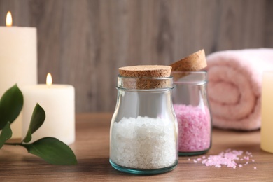 Glass jars with sea salt on wooden table