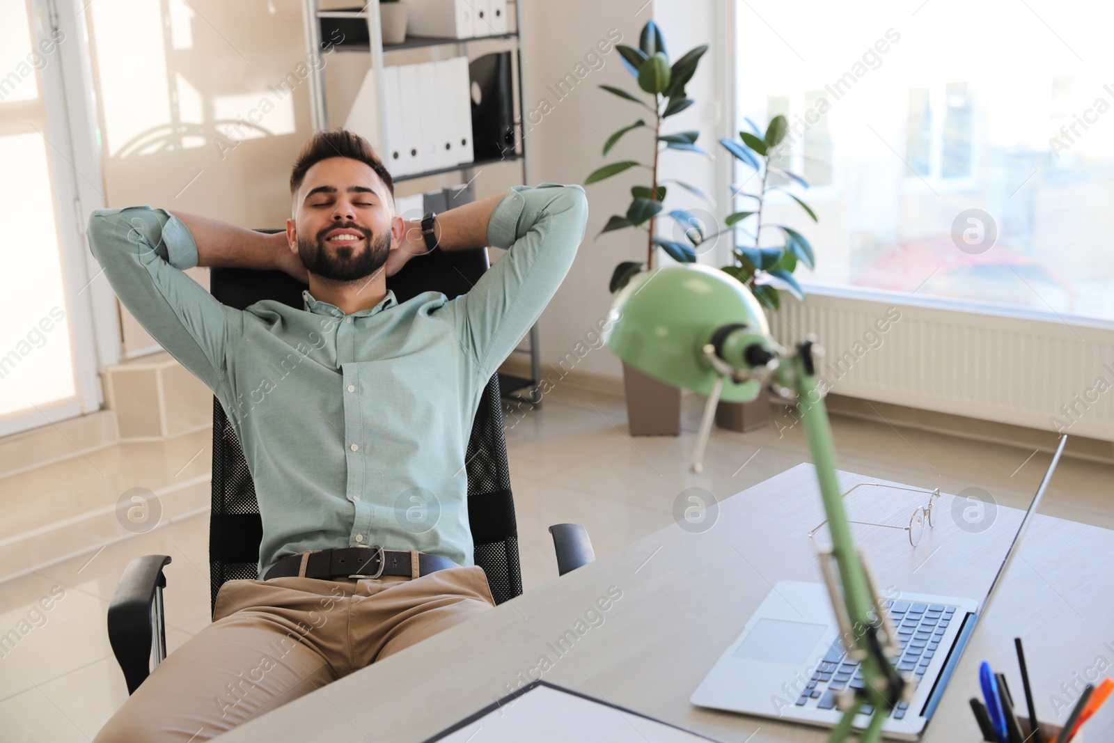 Photo of Businessman relaxing in office chair at workplace