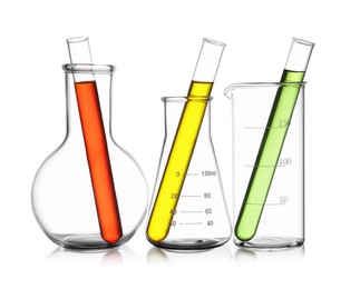 Photo of Glass flasks, beaker and test tubes with colorful liquids isolated on white