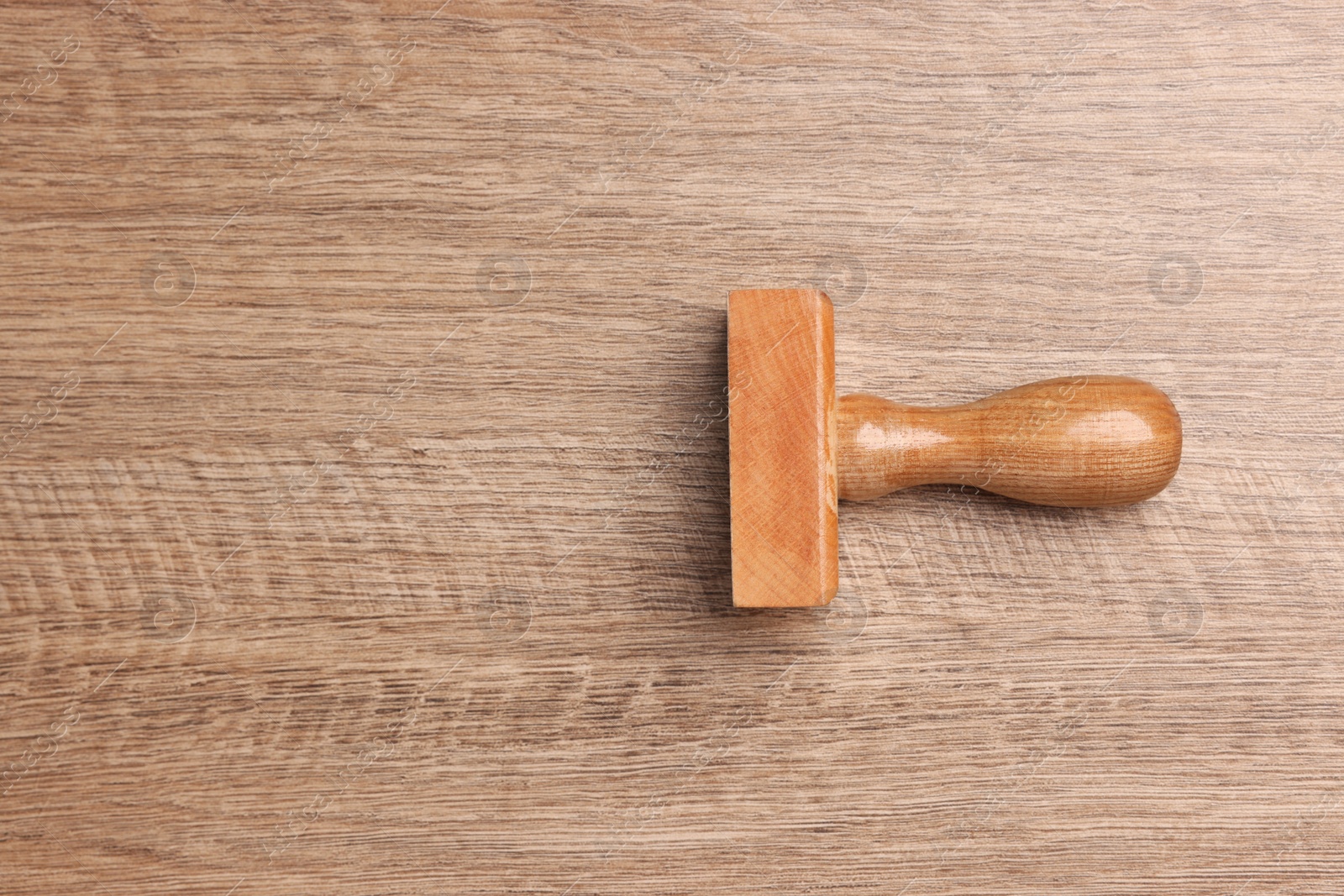 Photo of One stamp tool on wooden table, top view. Space for text