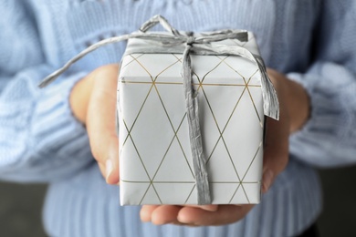 Woman holding beautiful Christmas gift with bow, closeup