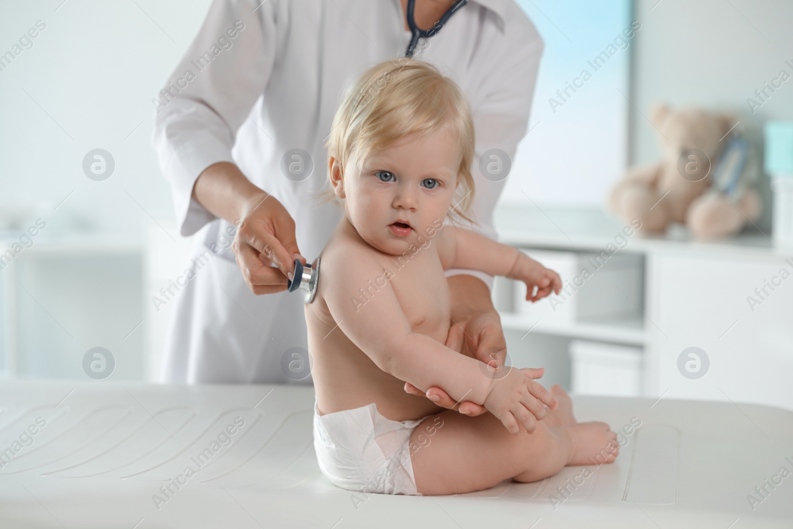 Photo of Pediatrician examining baby with stethoscope in hospital. Health care