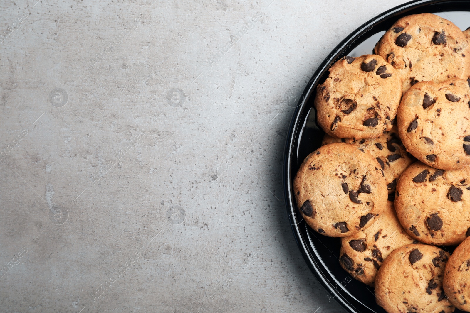 Photo of Plate with chocolate cookies and space for text on gray background, top view