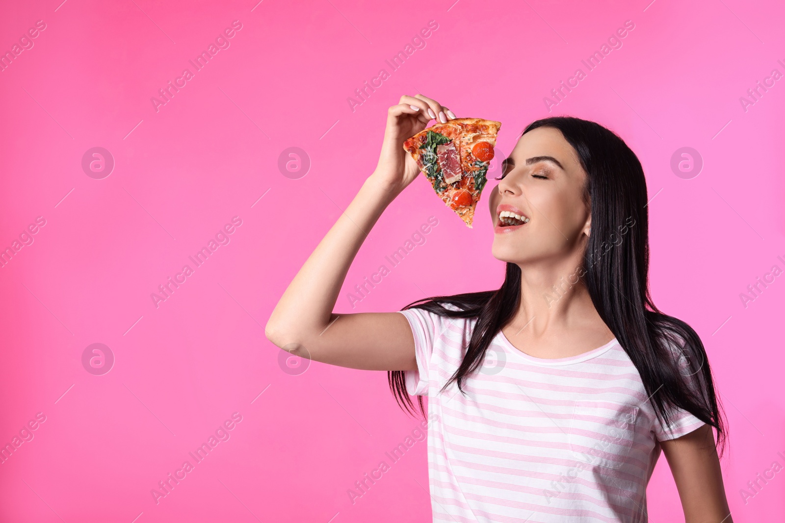 Photo of Beautiful woman with pizza on pink background, space for text