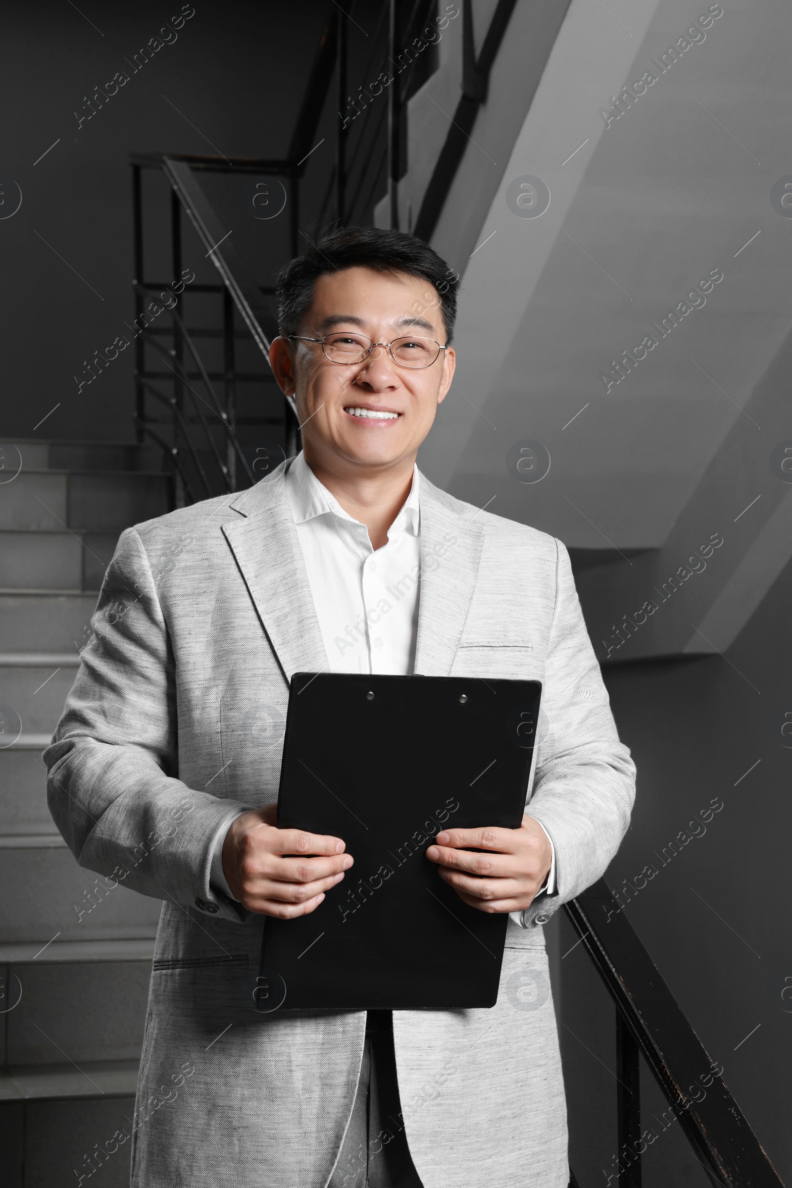 Photo of Happy boss with clipboard in his office