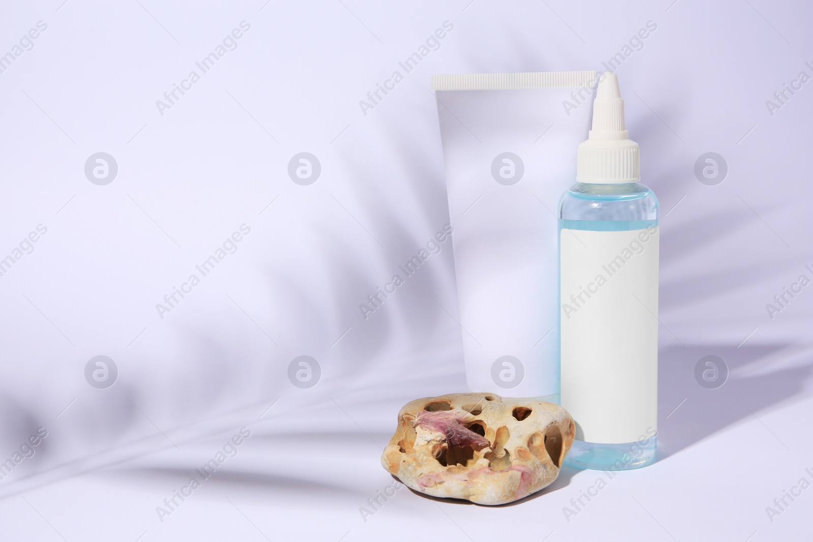 Photo of Cosmetic products, beautiful stone and shadow of tropical leaf on white background. Space for text
