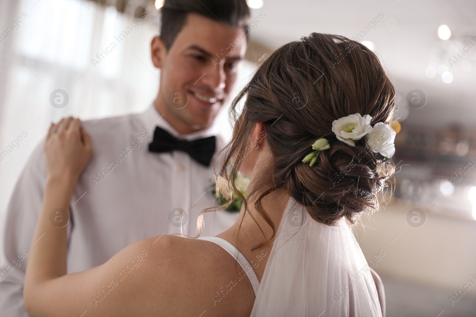 Photo of Happy newlywed couple dancing together in festive hall