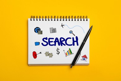 SEO concept. Notebook with word SEARCH and different drawings on yellow background, top view
