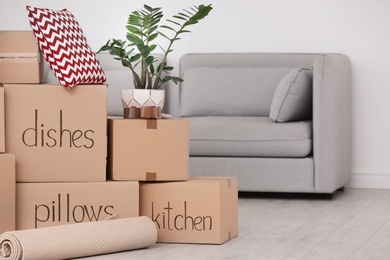 Photo of Pile of moving boxes and household stuff in living room