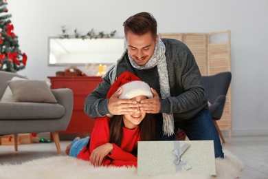 Happy young couple celebrating Christmas at home